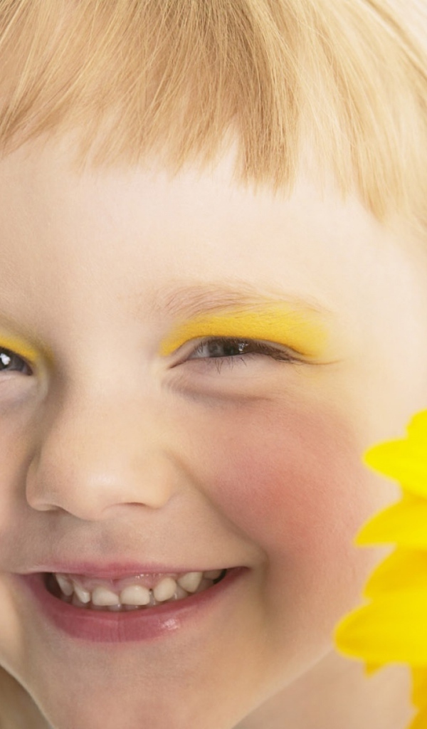 Улыбающаяся девочка с желтым цветком герберы