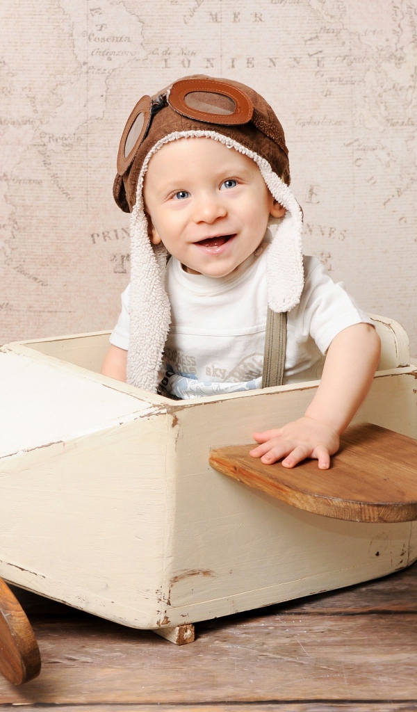 Улыбающийся маленький мальчик в игрушечном самолете