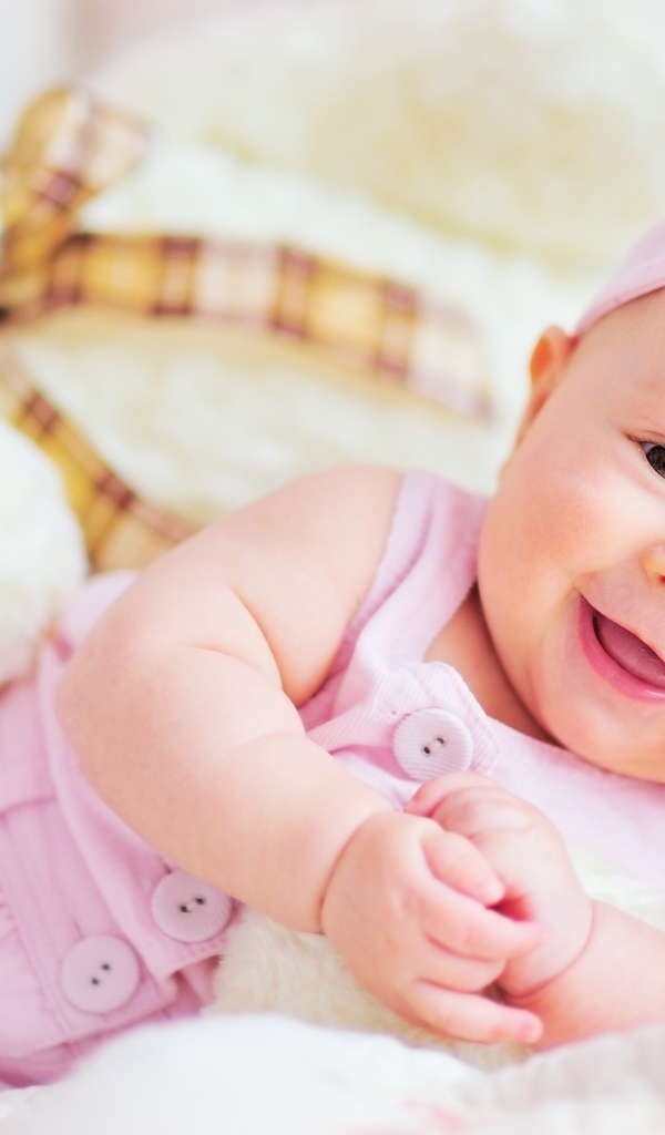 Улыбающаяся маленькая девочка с большим плюшевым медведем