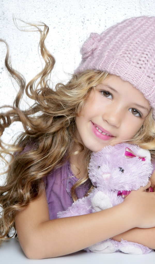 Милая светловолосая девочка с игрушкой