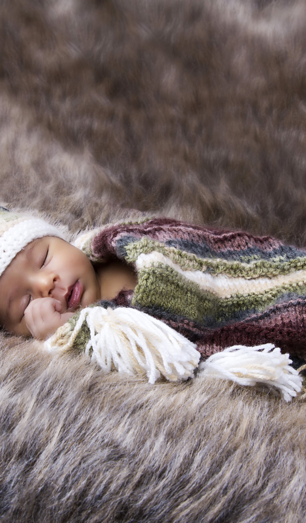 Младенец спит на меховом покрывале