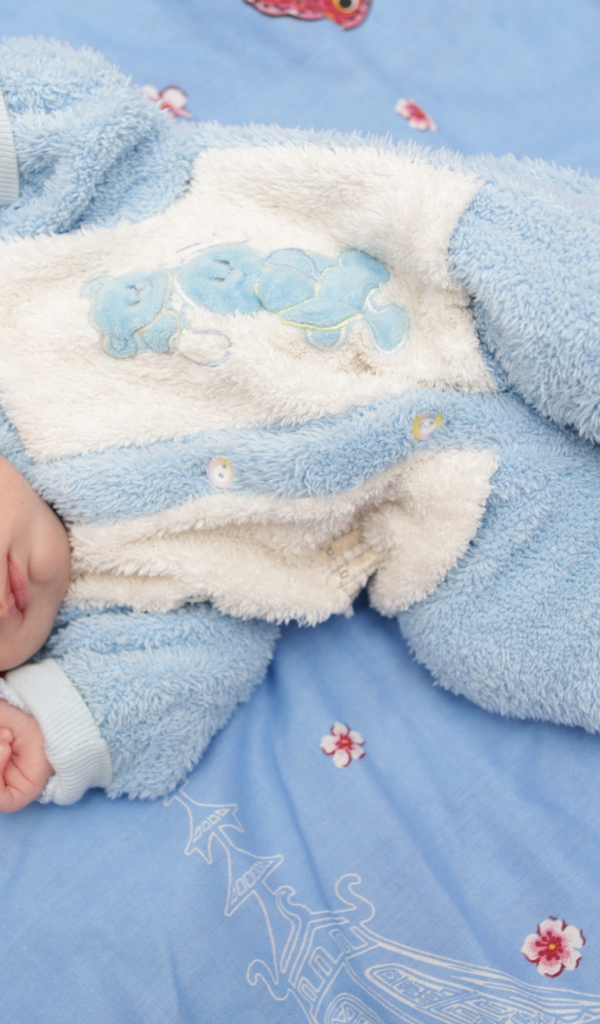 Грудной спящий ребенок в голубом костюме