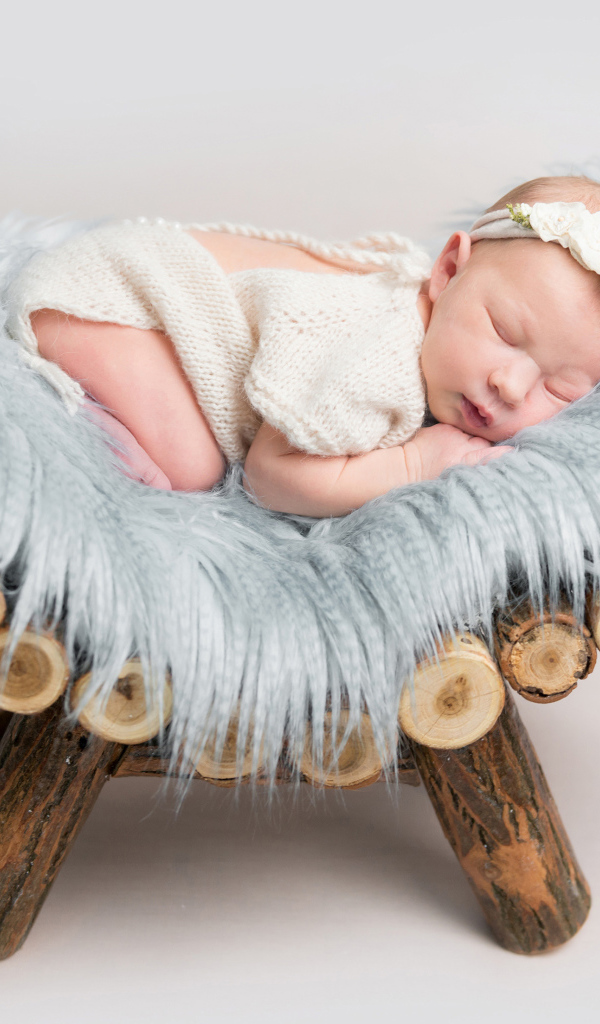 Грудной спящий ребенок лежит на деревянной кроватке