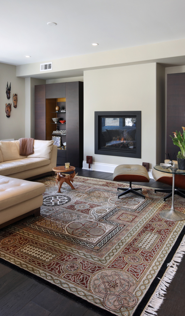 Стильная гостинная комната с белым кожаным диваном и ковром на полу