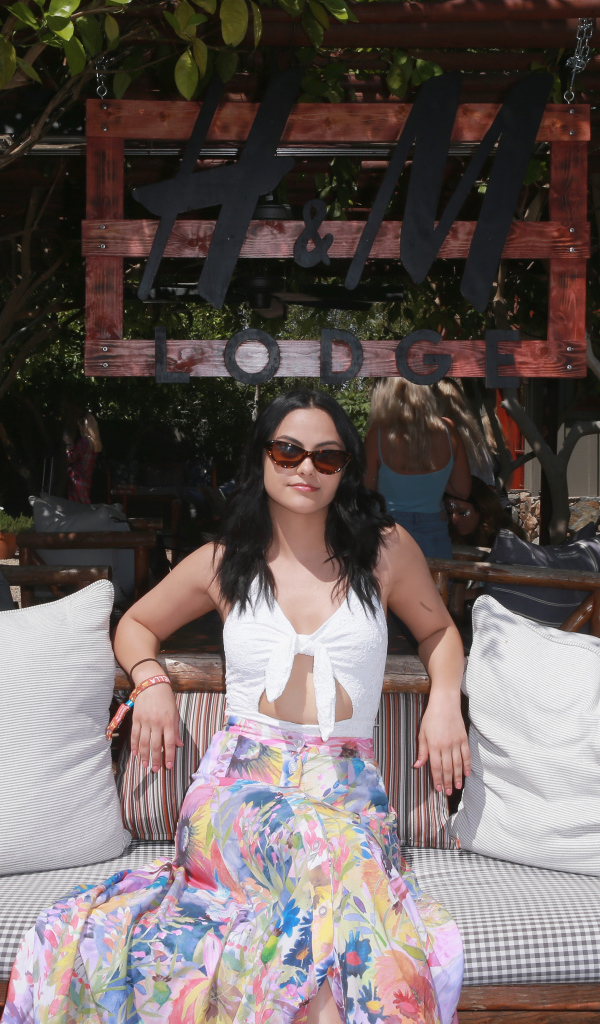 Актриса Камила Мендес сидит на диване в подушками