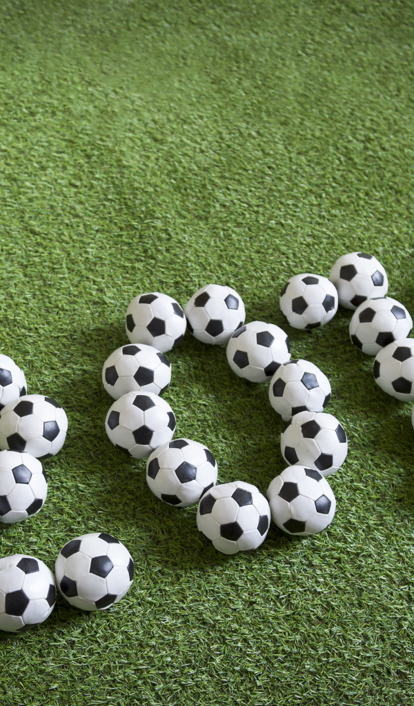 Цифры 2018 из футбольных мячей на зеленой траве
