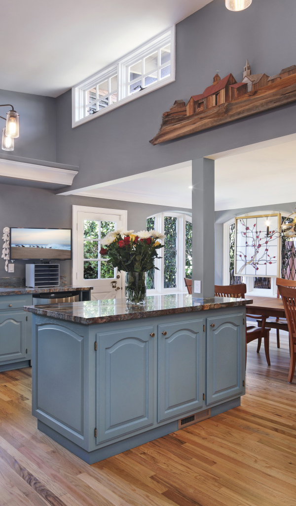 Большая красивая кухня в сером цвете с деревянным столом