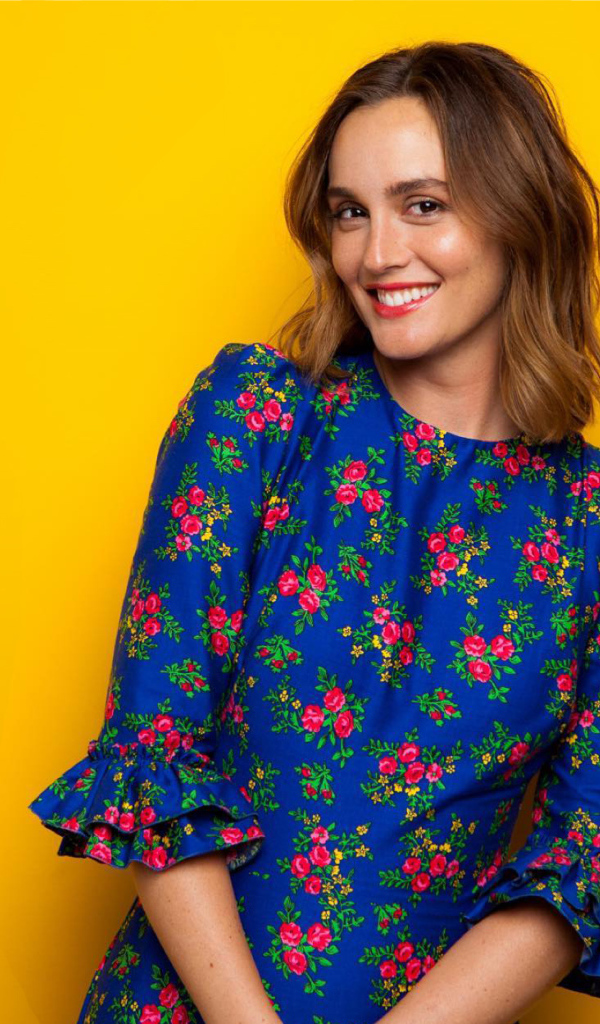 Улыбающаяся актриса Лейтон Мистер в красивом платье на желтом фоне 