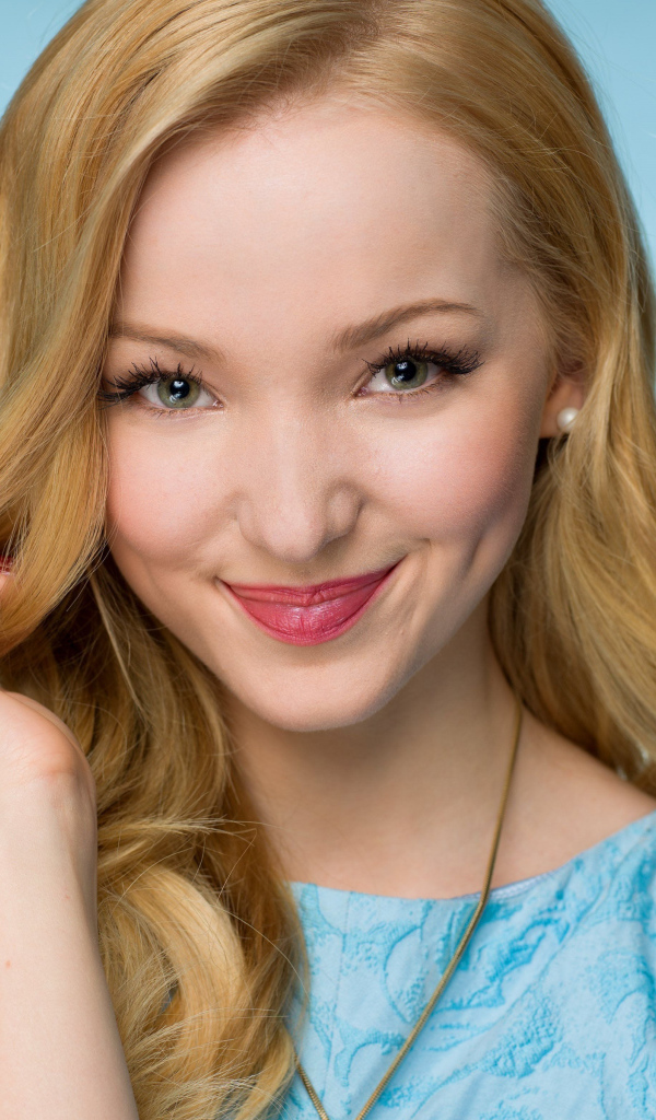 Улыбающаяся красивая девушка актриса Дав Кэмерон на голубом фоне