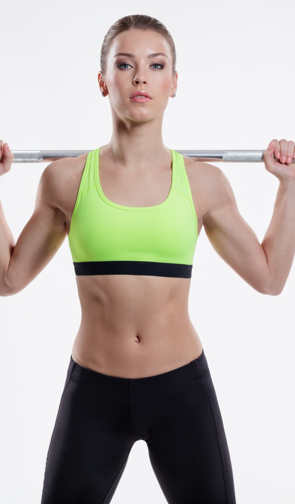 Спортивная девушка со штангой на плечах