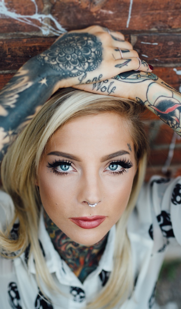 Молодая девушка блондинка с татуировками по телу