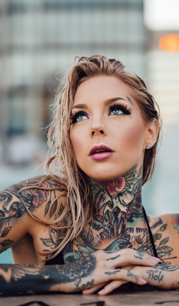 Молодая девушка с красивыми татуировками на теле