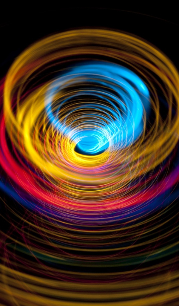 Разноцветные круги в воронке на черном фоне