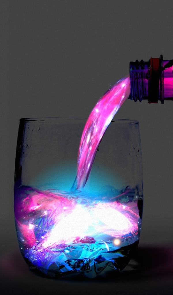 Неоновую воду наливают из бутылки в стакан 