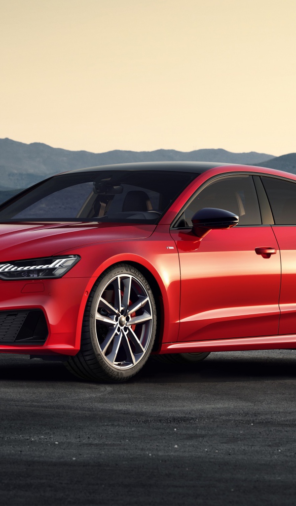 Красный автомобиль Audi A7 Sportback 55 TFSI E Quattro S Line 2019 года в горах