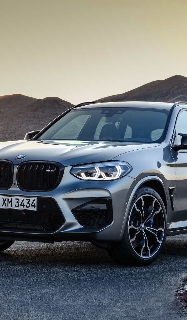 Серебристый автомобиль BMW X3  на асфальте