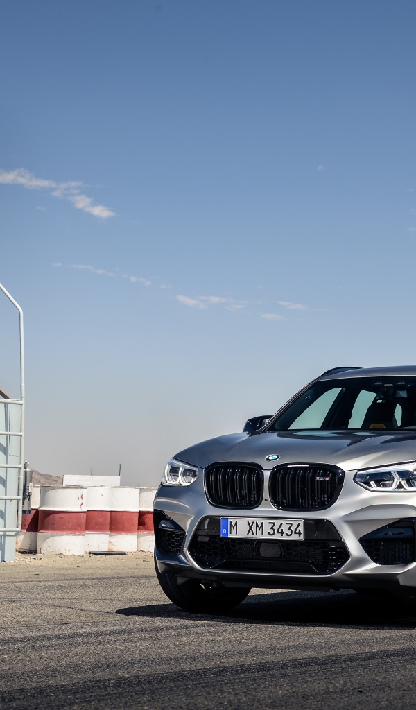 Серебристый автомобиль BMW X3 на асфальте