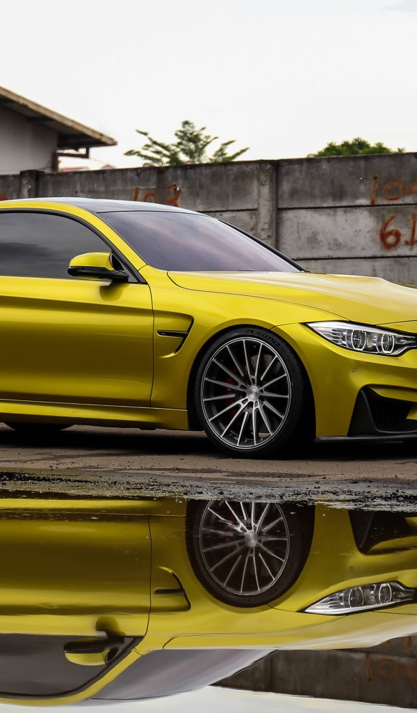Желтый автомобиль BMW M5 отражается в воде 