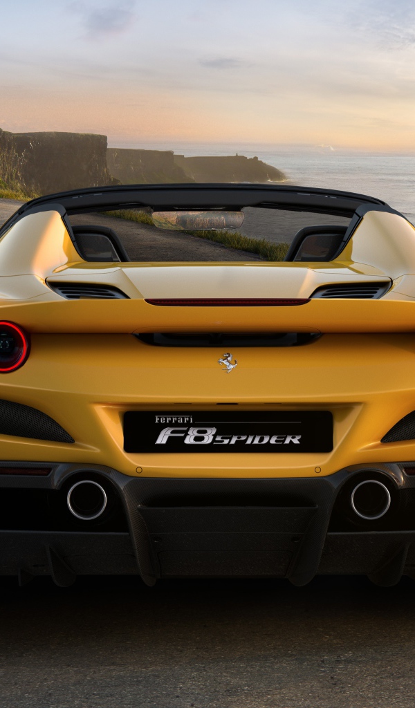 Желтый спортивный автомобиль Ferrari F8 Spider 2019 года на дороге у моря