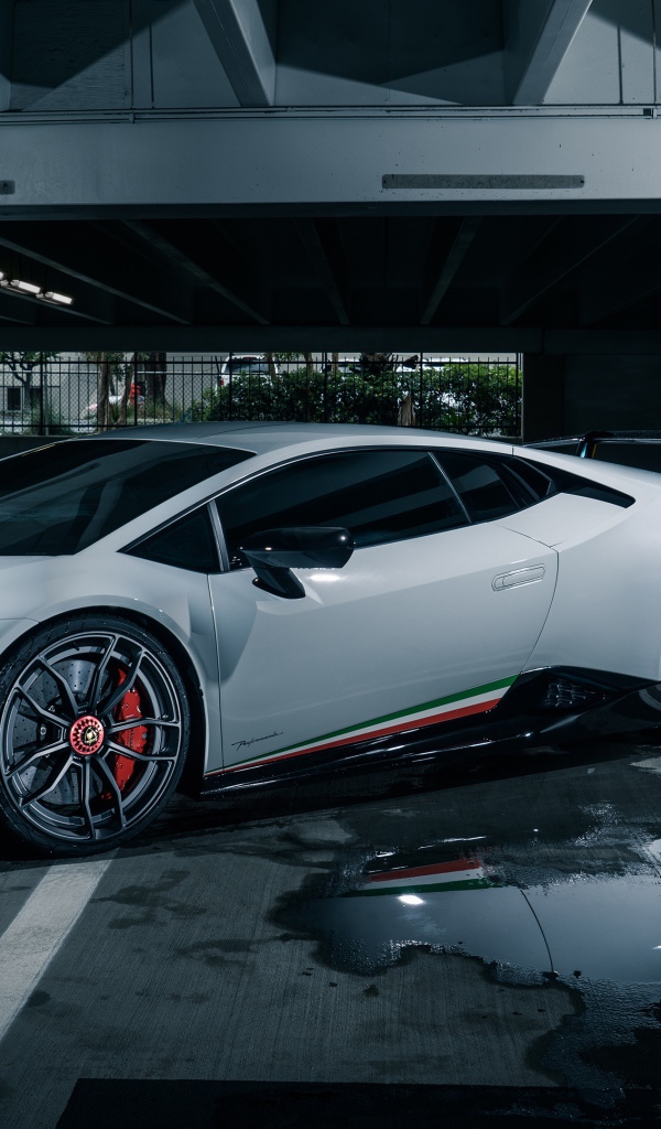 Белый спортивный автомобиль Lamborghini Aventador на подземной парковке