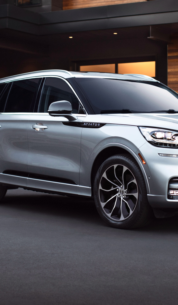 Серебристый внедорожник Lincoln Aviator Grand Touring, 2020 года на фоне дома