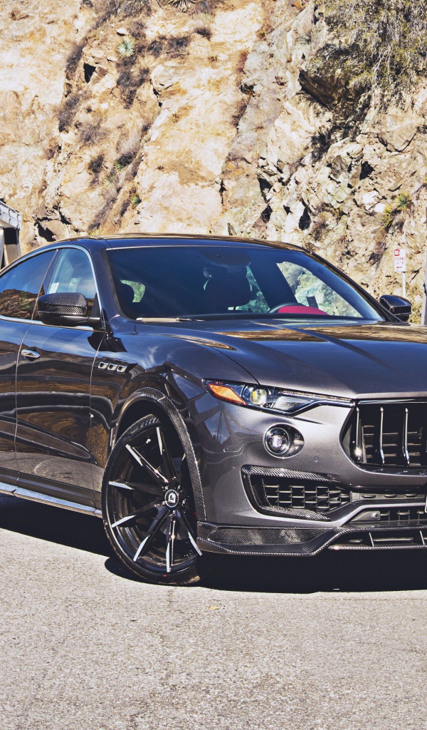 Внедорожник Maserati Levante на мосту на фоне гор