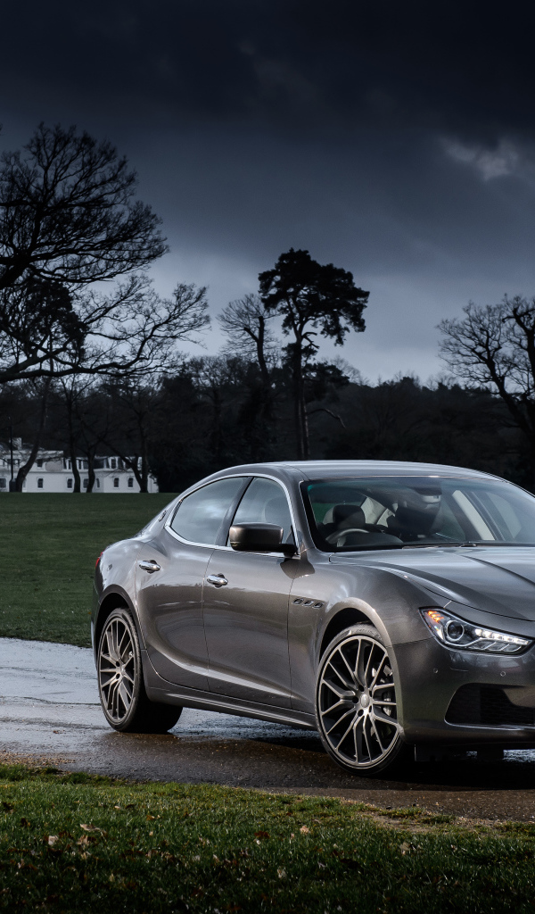 Серебристый автомобиль Maserati Ghibli на фоне грозового неба