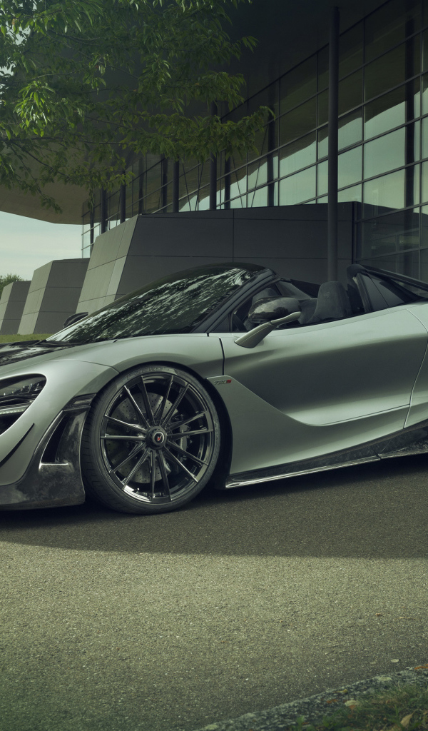 Серебристый автомобиль McLaren 720S Spider 2019 года у дома