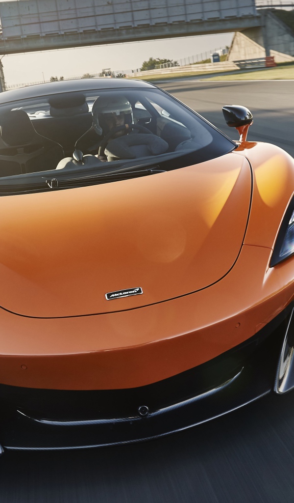 Спортивный оранжевый автомобиль McLaren 600LT 2019 года на трассе