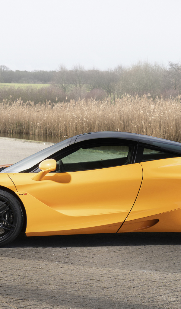 Желтый спортивный автомобиль McLaren MSO 720S Spa, 2019 года у воды