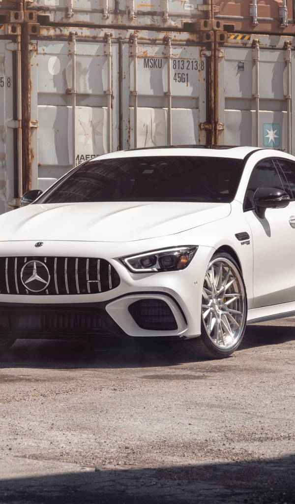 Белый автомобиль Mercedes-AMG GT 63 S стоит у контейнеров