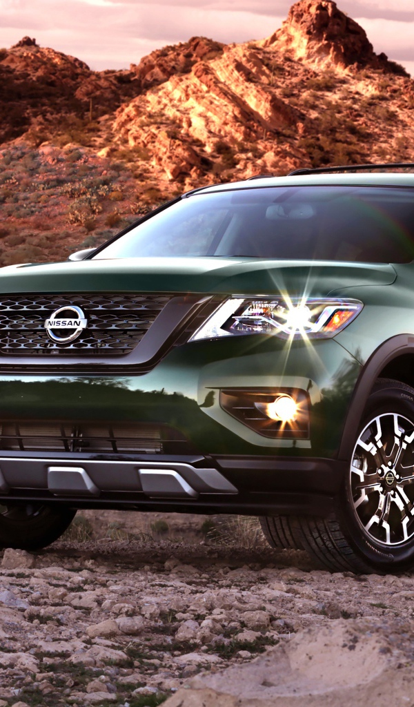 Зеленый автомобиль Nissan Pathfinder в горах 