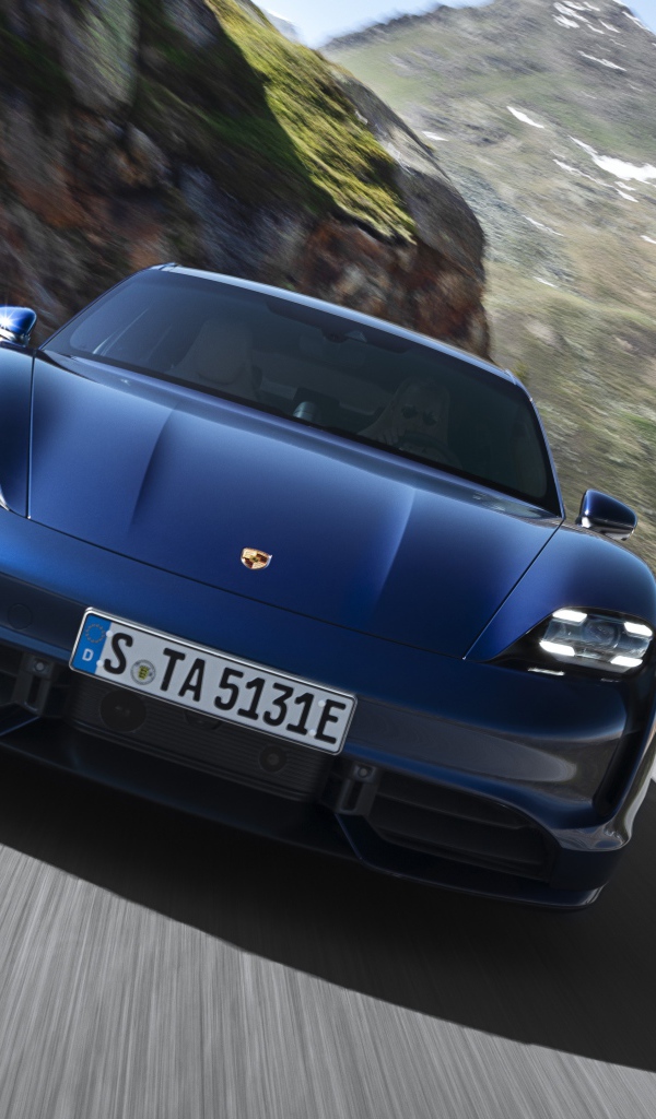 Синий автомобиль Porsche Taycan Turbo 2019 года на фоне гор