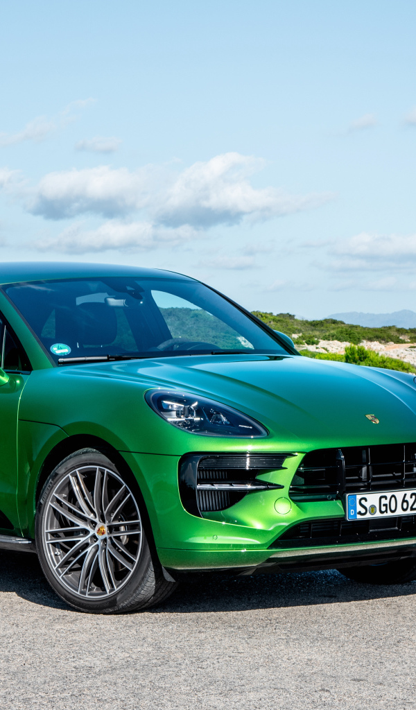 Зеленый внедорожник Porsche Macan S,  2018 года на фоне горизонта 