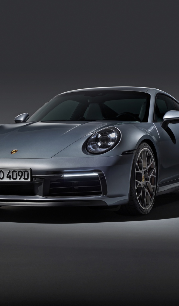 Серебристый автомобиль Porsche 911 Carrera 4S на сером фоне