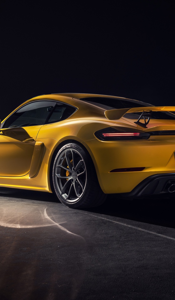 Желтый автомобиль Porsche 718 Cayman GT4, 2019 года вид сзади