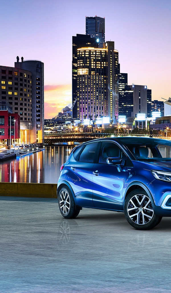 Стильный синий автомобиль Renault Captur на фоне города