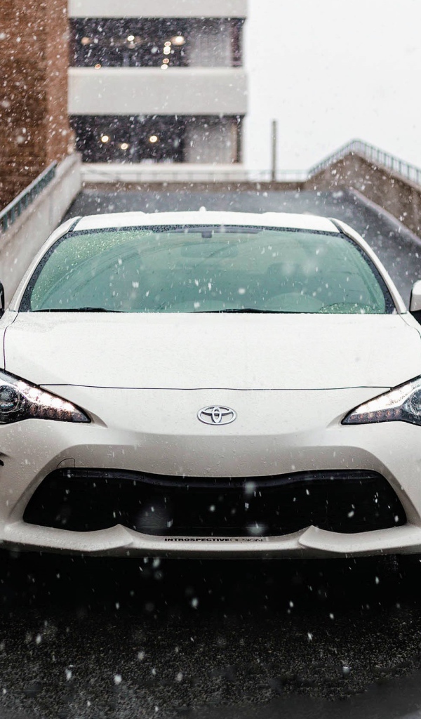 Белый автомобиль Toyota Supra на улице зимой