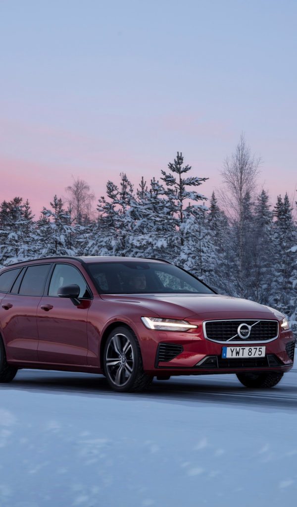 Красный автомобиль Volvo V60 на зимней дороге