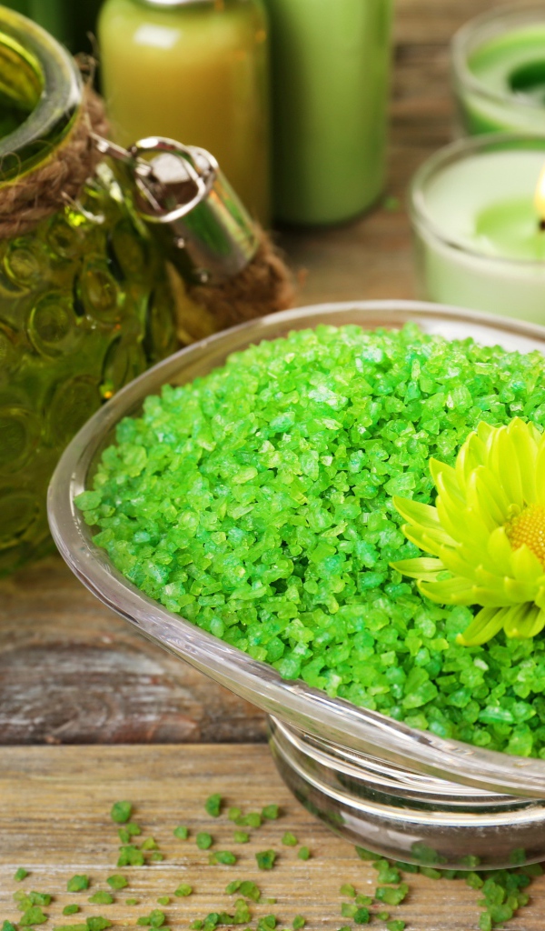 Зеленая ароматная морская соль на столе с зажженными свечами