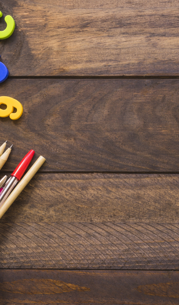 Банка с канцелярскими принадлежностями на деревянном столе с цифрами