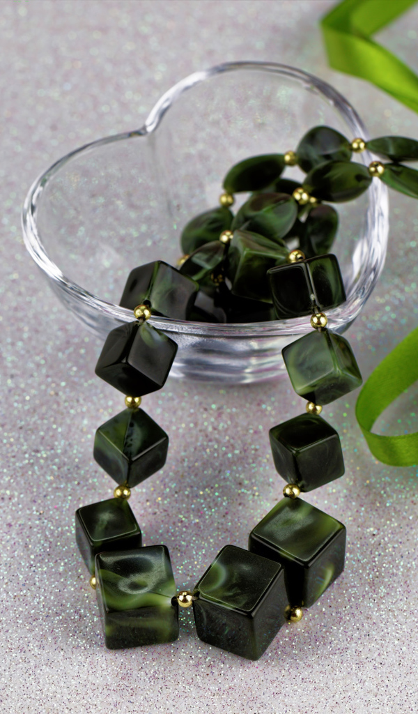 Ювелирное изделие с  бантиком в стеклянной вазочке на столе