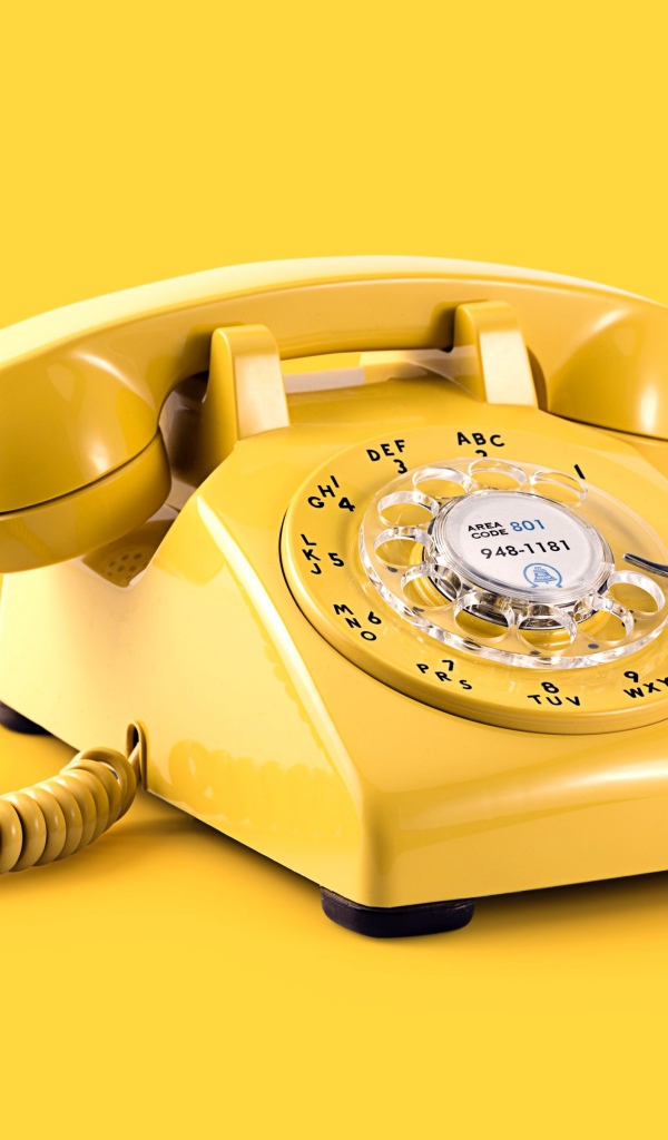 Старый желтый телефон на желтом фоне