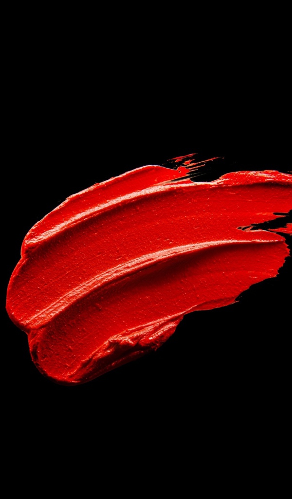 Мазок красной краски на черном фоне