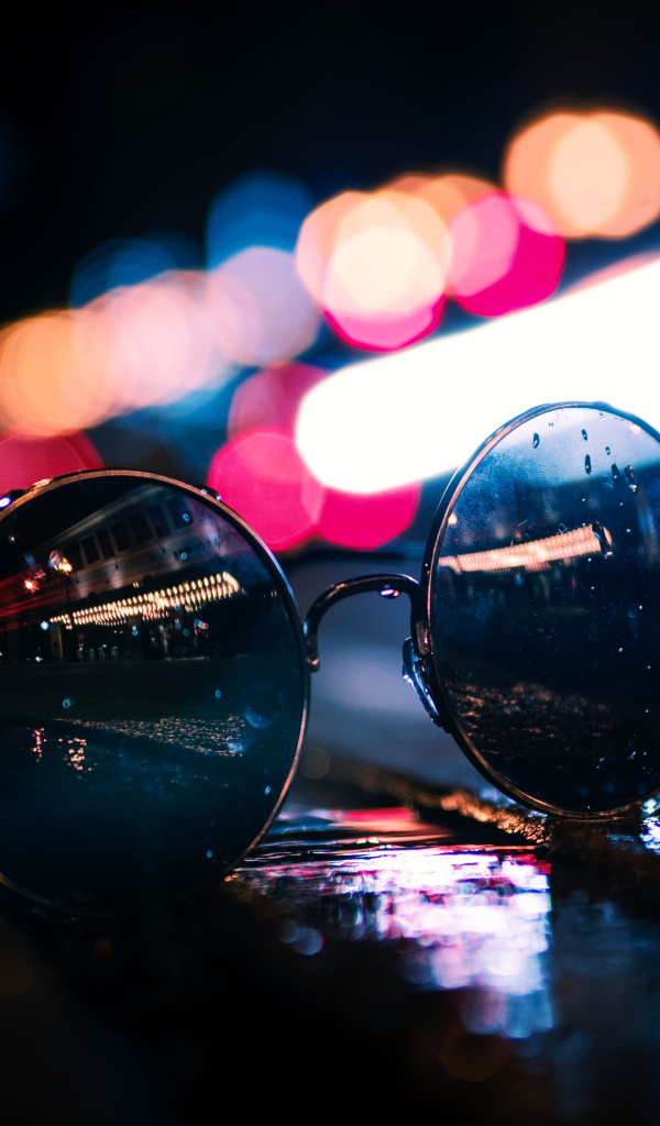 Солнцезащитные очки лежат на мокром асфальте