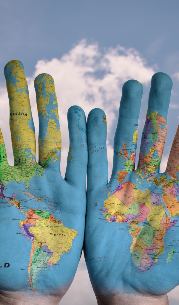 Карта мира нарисована на ладонях на фоне неба