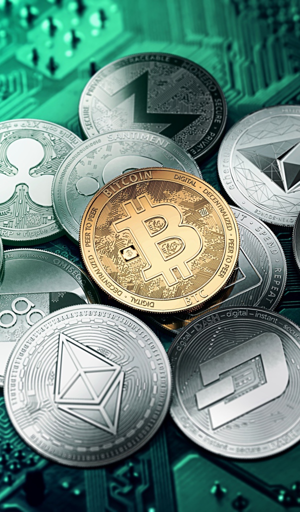 Монеты криптовалют лежат на компьютерной плате