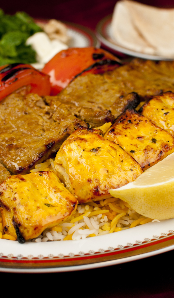 Аппетитное блюдо на тарелке с помидорами и лимоном