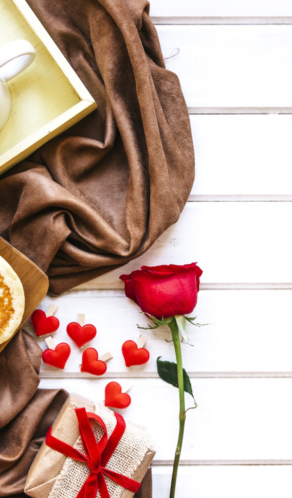 Выпечка на столе с кофе, подарком и красной розой