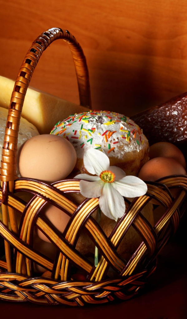Корзина с пасхальными угощениями у стены 